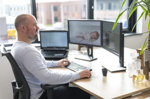 Een webdeveloper voert WordPress onderhoud uit op een werkplek met twee monitoren.